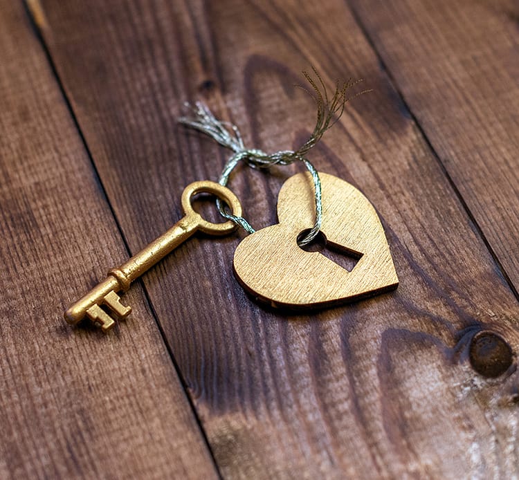 Goldener Schlüssel mit Herzanhänger als Symbol für Motivation, Werte, persönliche Stärken.